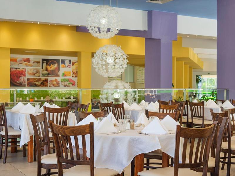 Elegant restaurant with white tablecloths, wooden tables and chairs in a calm atmosphere.