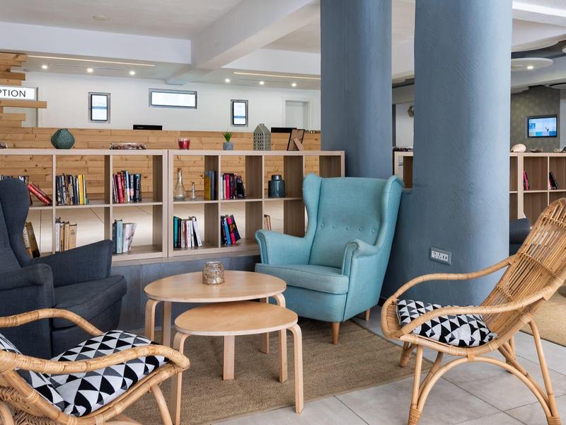 Cozy lobby with seating areas and bookshelves in a modern hotel.