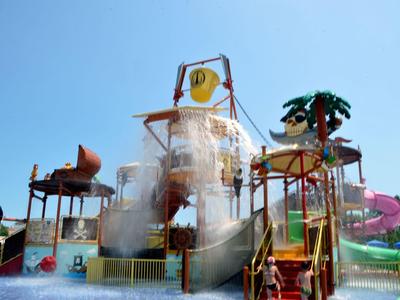 Parco acquatico con grandi scivoli e giochi d'acqua sotto un cielo limpido.