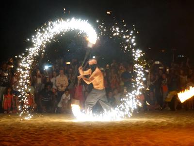 Feuertänzer führt eine spektakuläre Show am Strand bei Nacht auf.