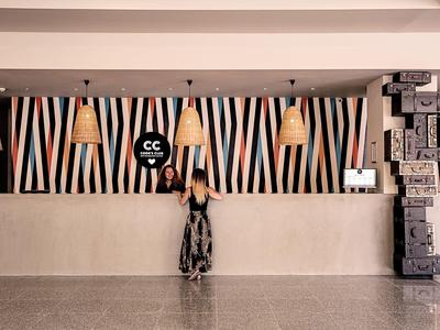 Groot buitenzwembad met ligstoelen en parasols voor een hotelgebouw.