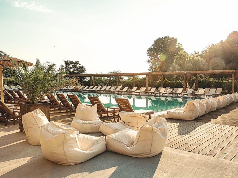 Moderne badkamer met wastafel, spiegel, bad met glazen afscheiding en lichte muren.