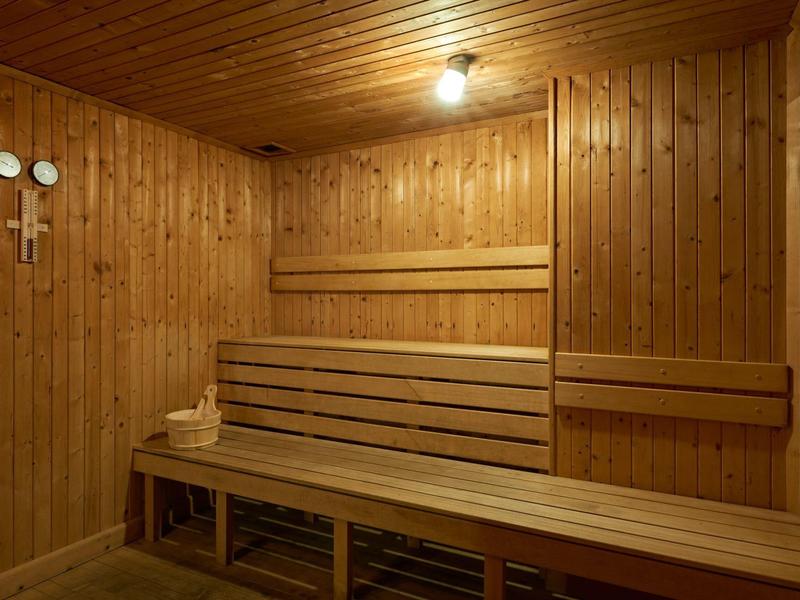 Houten sauna met banken en houten wanden binnen.