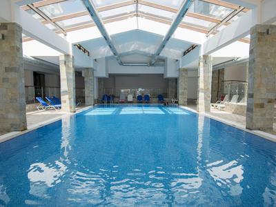 Beheiztes Hallenbad mit Blick auf Loungesessel und Glasschiebetüren