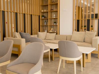 Modernes, gemütliches Lounge-Bereich mit beigen Sesseln und Sofas in hellem Interieur.