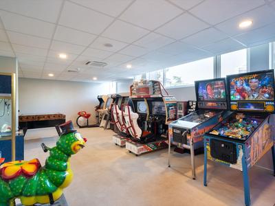 Pokój gier z automatami do gier i karuzelą dla dzieci w jasnym pomieszczeniu z oknami.