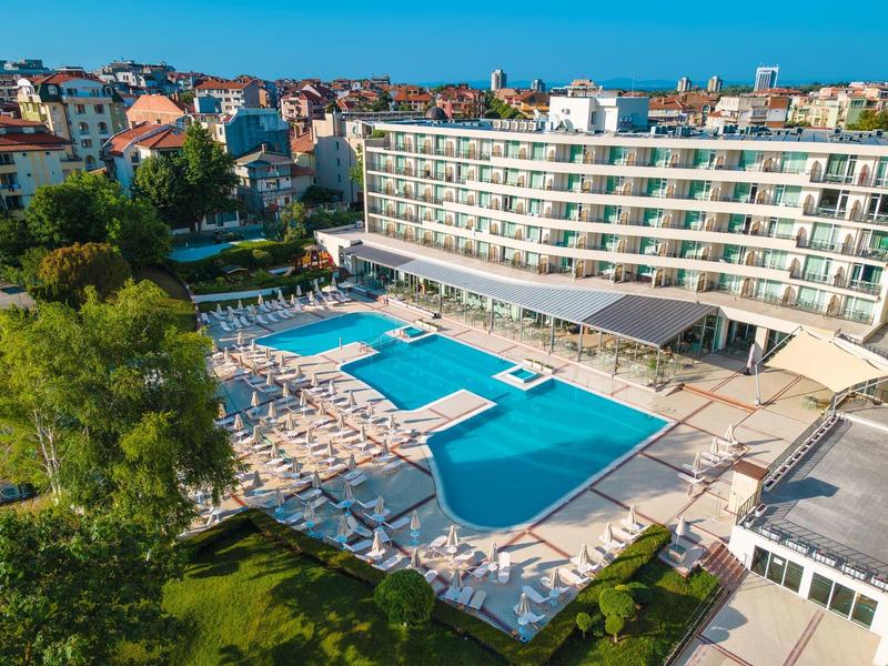 Grande hotel con più piscine e lettini prendisole in un ambiente urbano