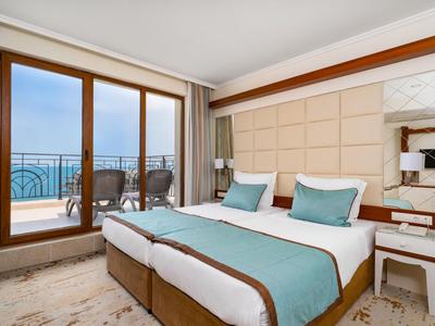 Modernes Hotelzimmer mit Doppelbett, Balkon und Meerblick.