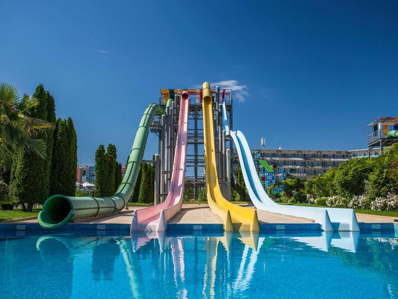 Felle glijbanen met een zwembad onder een heldere blauwe lucht