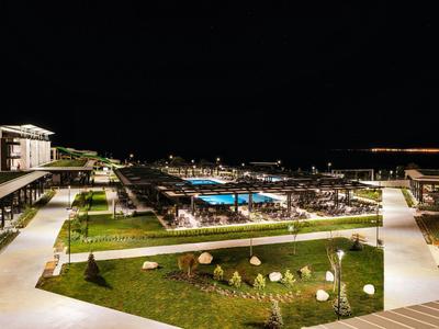 Espace extérieur moderne d'un hôtel avec piscine éclairée et sentiers la nuit
