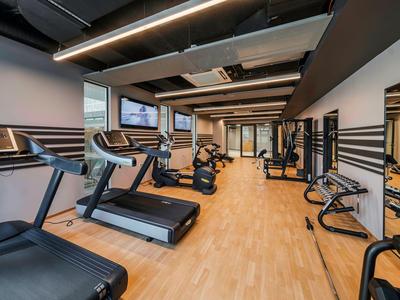 Gimnasio moderno con cintas de correr y equipos de ejercicio sobre suelo de madera clara