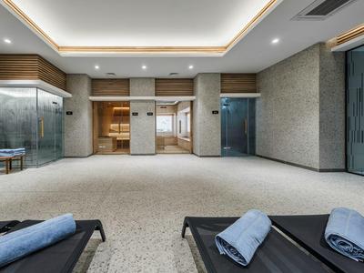 Espace bien-être moderne avec chaises longues et éclairage doux dans un hôtel.