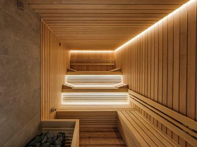 Salle de sauna moderne avec panneaux en bois et éclairage LED intégré.