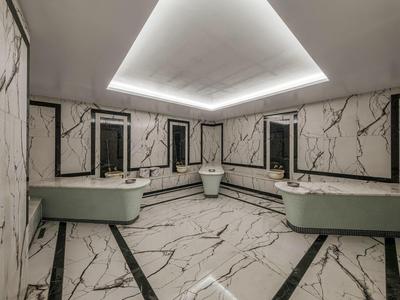 Espace bien-être luxueux avec sol en marbre et vasques grises arrondies.