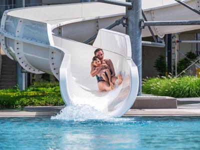 Mujer disfruta del tobogán y cae en la piscina del hotel.