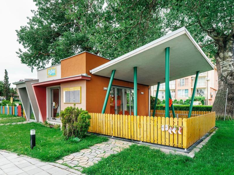 Modern kleurrijk tuinhuis met dakterras en omliggende tuin in groene omgeving.