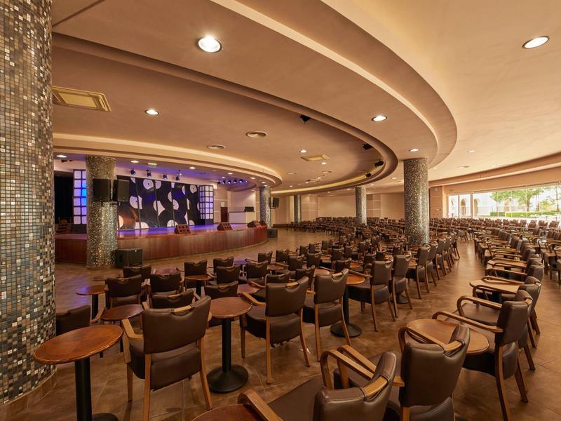 Large concert hall with rows of seats, stage, and modern lighting.