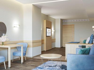 Moderner Wohnraum mit blauen Stühlen, grauem Sofa, rundem Tisch und Holzfußboden.