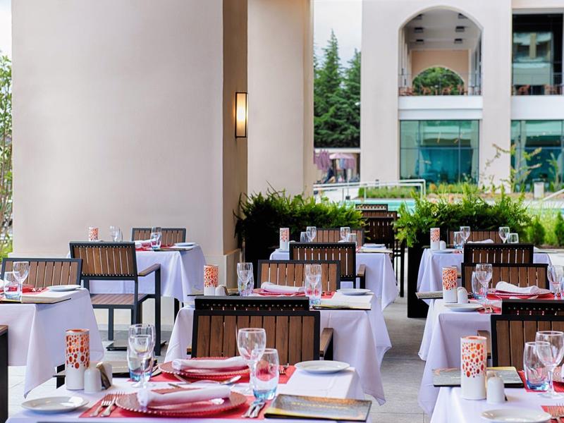 Moderner Innenpool mit großer Glasfront, Holzbalkendecke und Liegestühlen am Beckenrand.