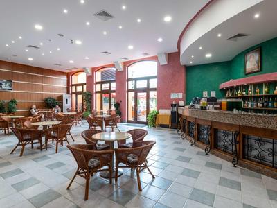 Restaurante de hotel amplio y luminoso con muebles de madera y gran barra