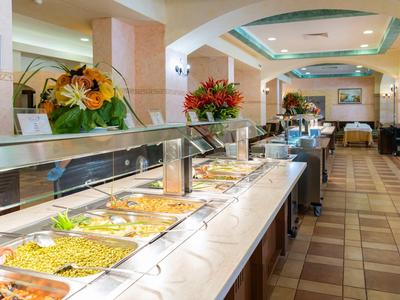 Buffet with hot dishes in a bright, modern dining room.