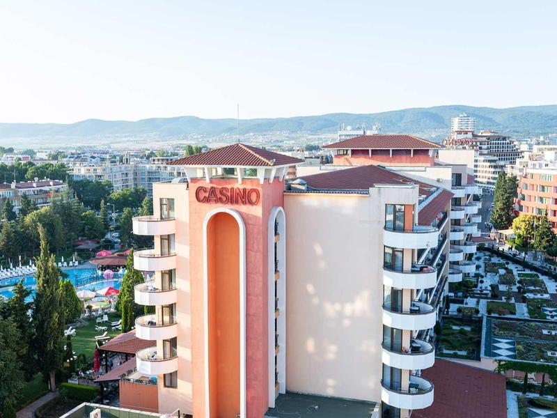 View of a hotel building with casino sign, surrounding pools, and cityscape