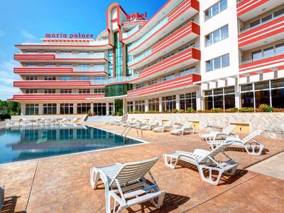 Large multi-story hotel with outdoor pool and lounge chairs on the terrace.