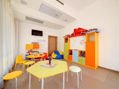 Bright playroom with colorful furniture, tables, and chairs in a hotel.