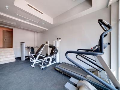 Gimnasio moderno con equipos de ejercicio y grandes ventanas