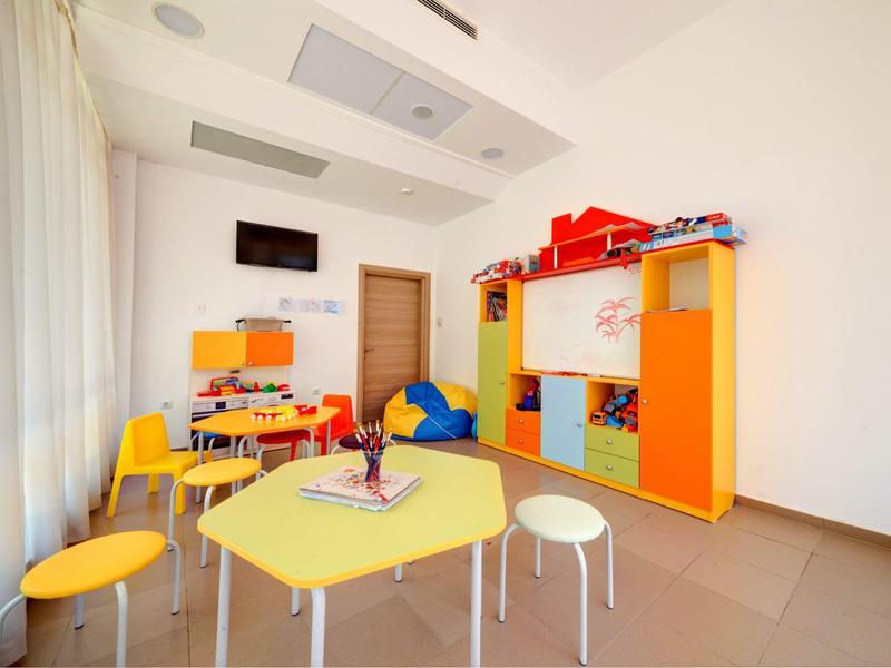 Bright playroom with colorful furniture, tables, and chairs in a hotel.