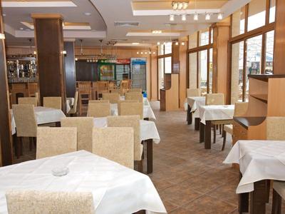 Interior of a bright, modern restaurant with set tables and chairs.