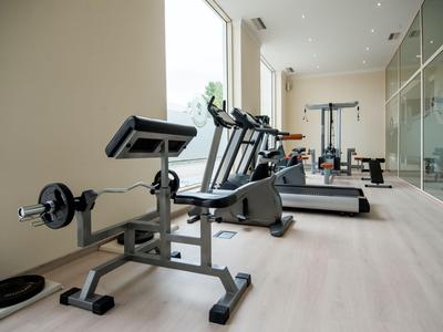 Lichte fitnessruimte met diverse fitnessapparatuur en grote ramen