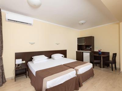 Hotelkamer met twee eenpersoonsbedden, bureau, magnetron en airconditioning.