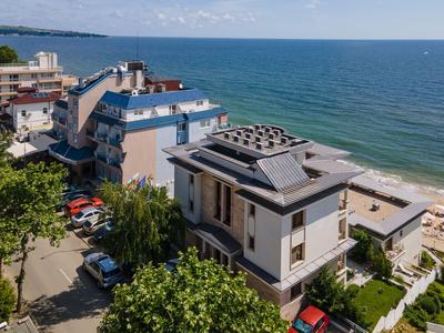 Mehrstöckiges Hotelgebäude mit Solarpaneelen an der Küste neben dem Meer