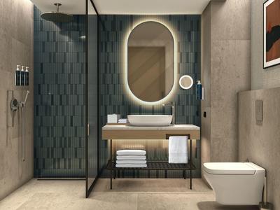 Modern bathroom with round illuminated mirror, freestanding sink, and walk-in shower.