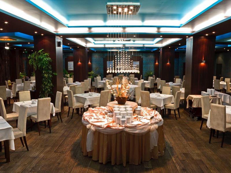 Elegant restaurant met feestelijk gedekte tafels en een centraal buffet onder warm licht.