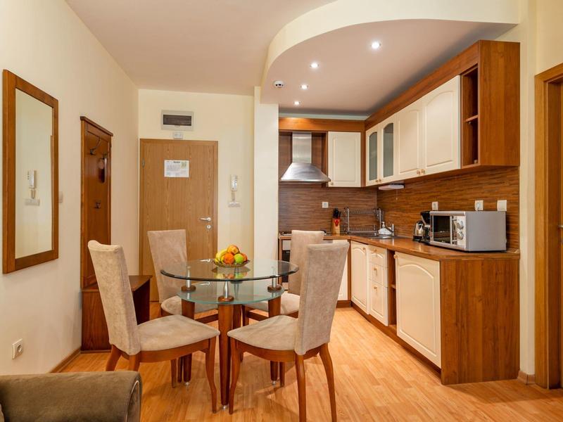 Kleine moderne kitchenette met eettafel en vier stoelen in een hotelappartement.