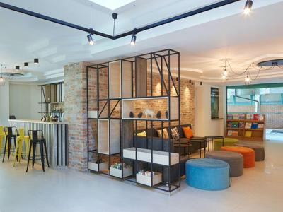 Moderne, lichte lounge met zitplaatsen, bar en planken in een hotel.