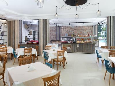 Elegant restaurant met gedekte tafels en modern interieur met grote ramen.