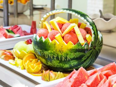 Frutta fresca come anguria e ananas servita in una ciotola decorativa di anguria.