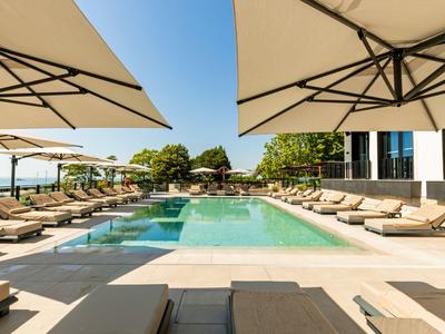 Moderner Pool mit Liegestühlen und Sonnenschirmen in einem Hotel