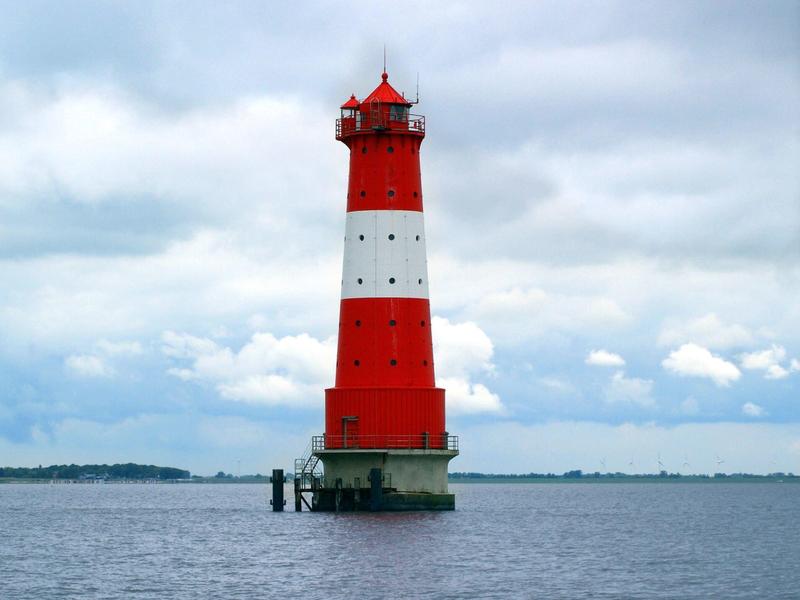 Roter und weißer Leuchtturm im Wasser unter bewölktem Himmel