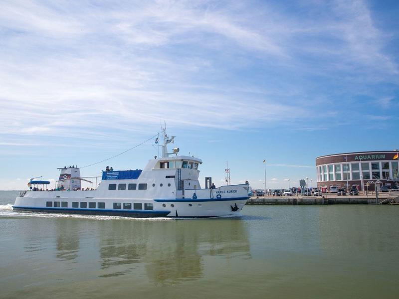 Weiße Fähre im Hafen bei Sonnenschein und leicht bewölktem Himmel