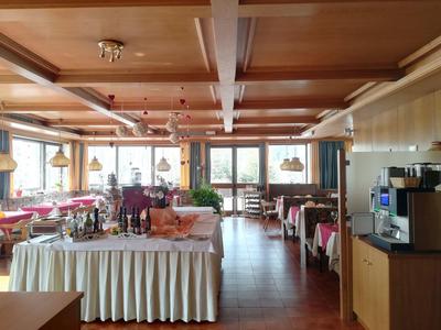 Großes, helles Restaurant mit Holztäfelung, vielen Tischen und einer Kaffee-Station rechts.