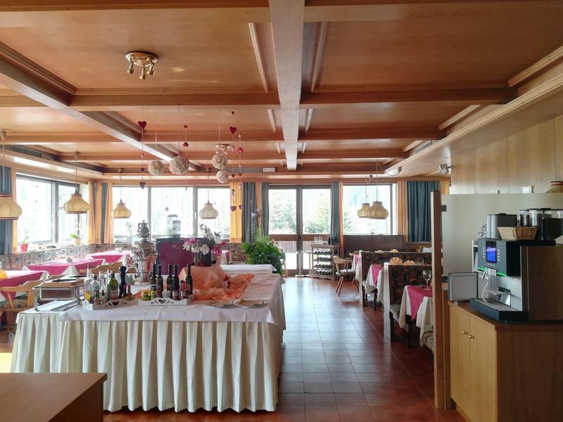 Großes, helles Restaurant mit Holztäfelung, vielen Tischen und einer Kaffee-Station rechts.