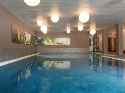 Innenpool mit stilvollen runden Hängelampen und moderner Wanddekoration.