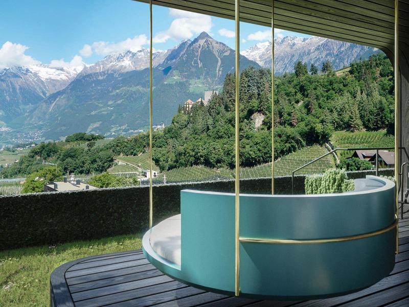 Moderne Hängeschaukel auf Terrasse mit Panoramablick auf Berge.