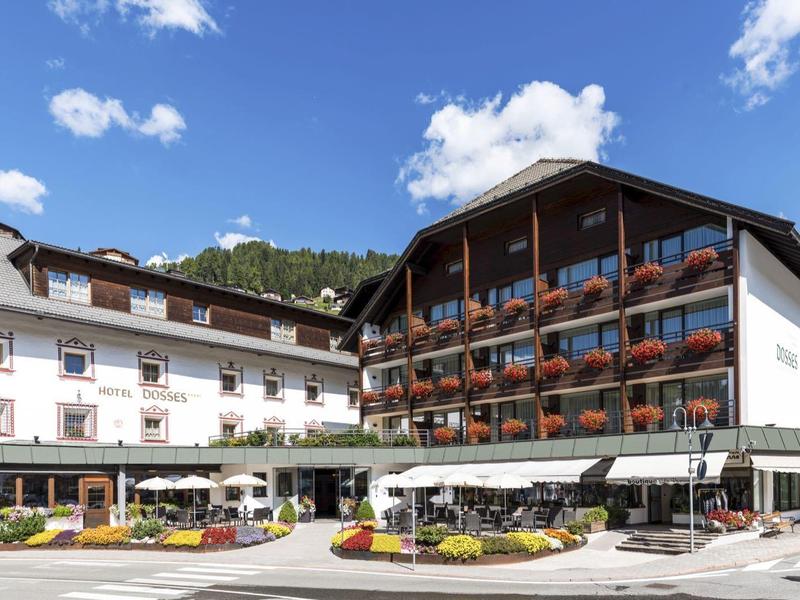 Großes Hotel mit traditioneller Architektur unter blauem Himmel und weißen Wolken.