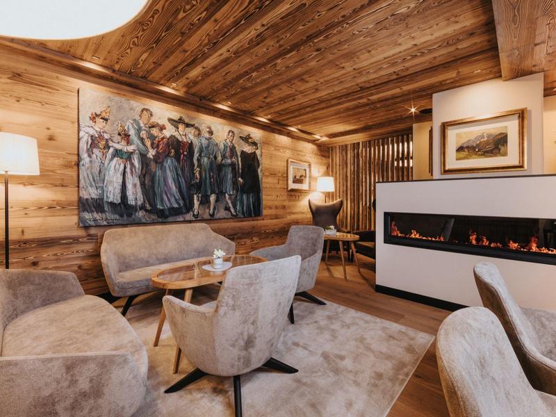 Gemütlicher Hotel-Loungebereich mit Holzwänden, moderner Beleuchtung und stilvoller Kunst an der Wand.