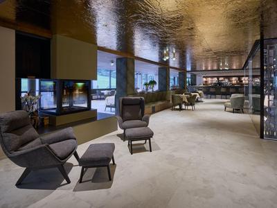 Moderne Hotellobby mit komfortablen Sesseln, Teppichboden und schwarzer Decke.
